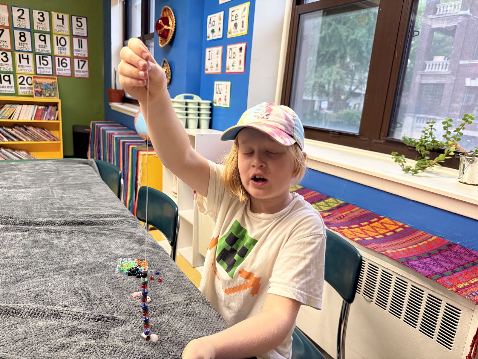 Student holding up a finished beaded strand